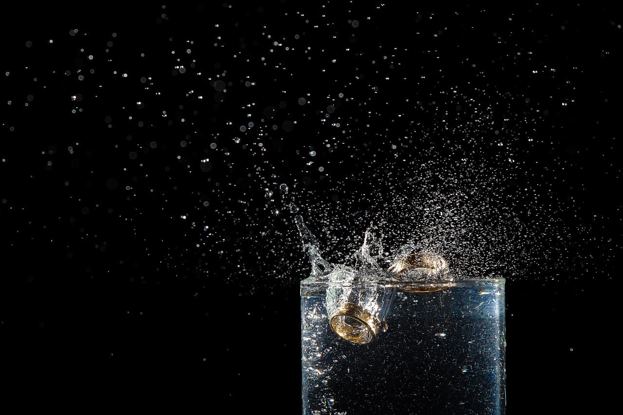 Anillos de matrimonio en un vaso con agua. Metáfora para mantenr relaciones sanas.