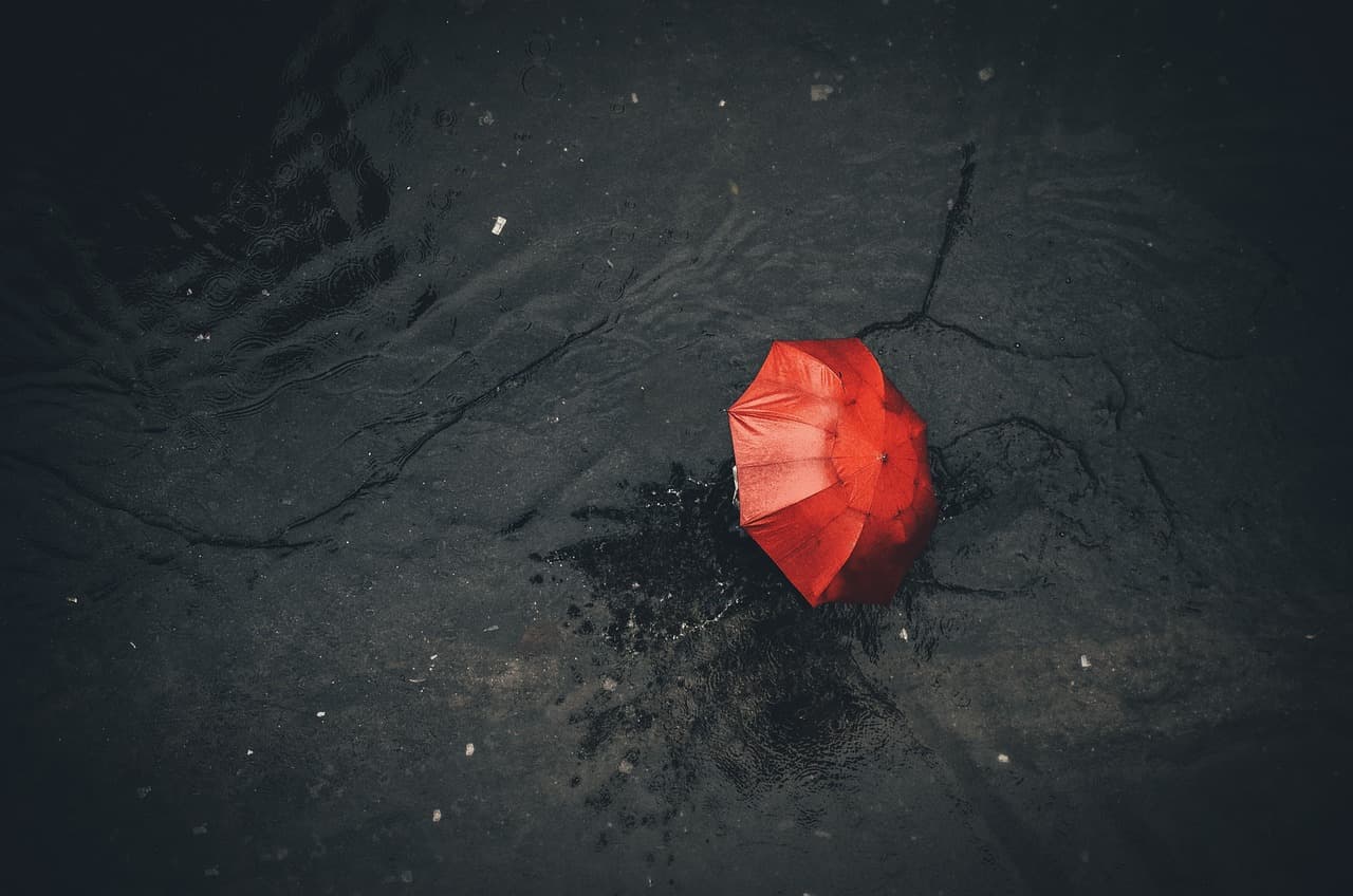 Lluvia y paraguas rojo ausente